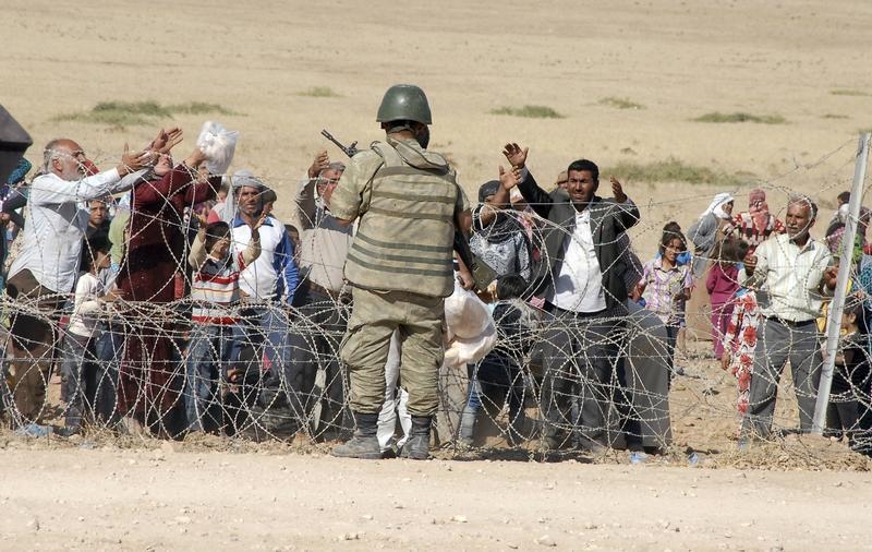 Curdos parados na fronteira com a Turquia em fuga no EI- na regiao de kobani (Reuters)
