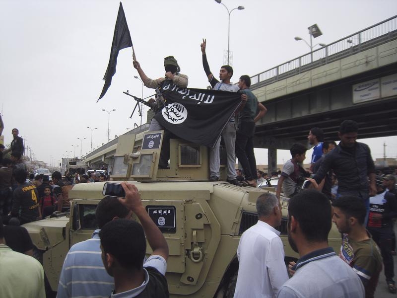 Homens do EI celebram presença em Faluja sobre um veiculo armado iraquiano 30 março 2014 Reuters